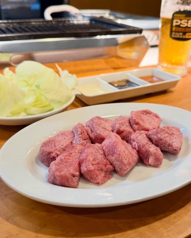 皿に盛った厚切りの肉と卓上の焼き台