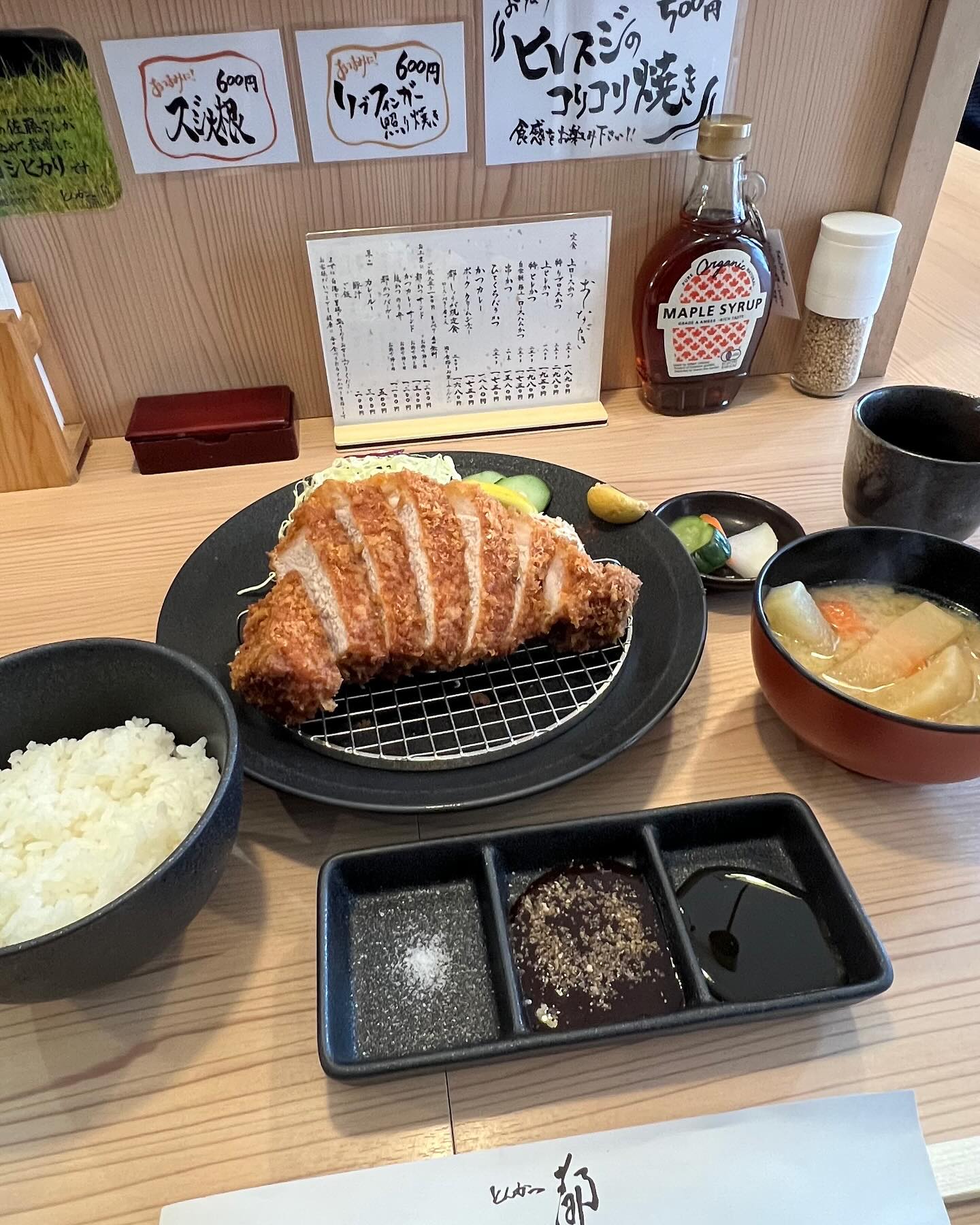 とんかつ、ご飯、豚汁と卓上のメイプルシロップ